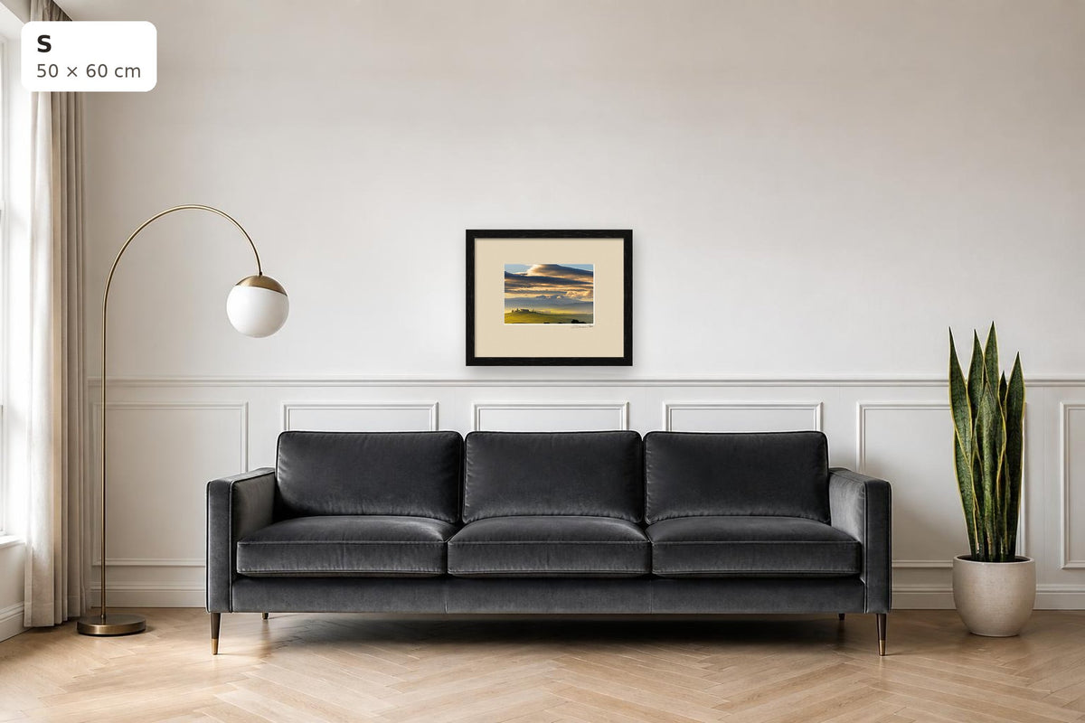 Dawn in Val d’Orcia – fine art print by Duccio Nacci, size S with thin black frame shown above a sofa