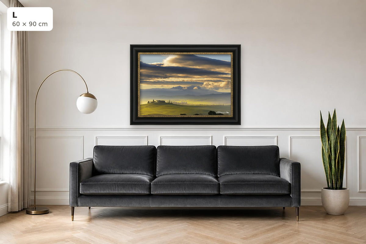 Dawn in Val d’Orcia – fine art print by Duccio Nacci, size L with black and gold frame shown above a sofa