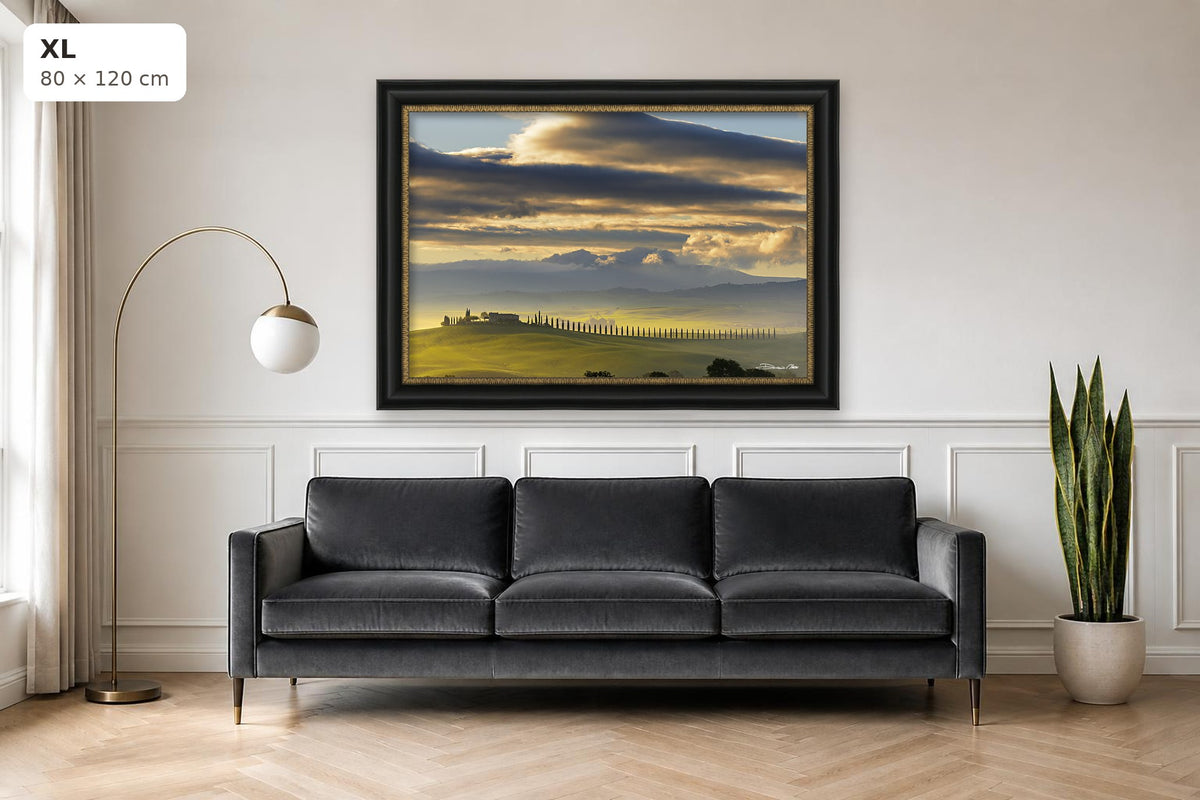 Dawn in Val d’Orcia – fine art print by Duccio Nacci, size XL with black and gold frame shown above a sofa