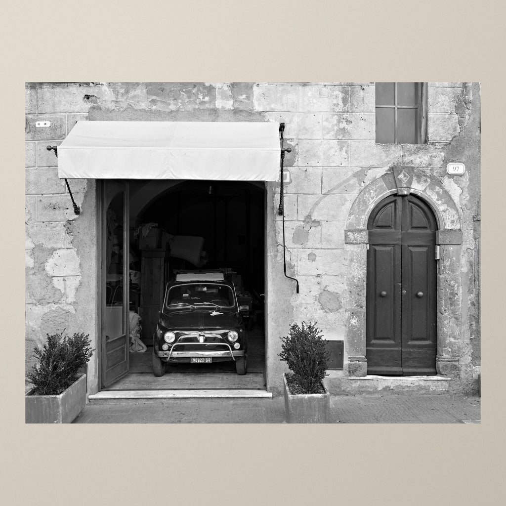 The Hidden 500 – A Fiat 500 peeks out of an old stone garage in a Tuscan village – photograph by Duccio Nacci